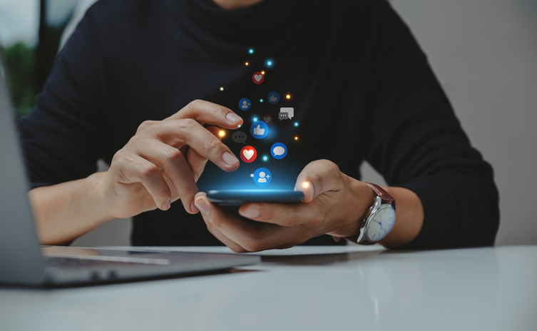 Man using smartphone with social media icons SociShare Social Media Management